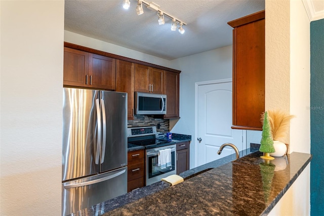 4221 W Spruce St Unit 1303, Tampa, FL 33607 - kitchen with appliances with stainless steel finishes, tasteful backsplash, dark stone counters, a sink, and a textured ceiling