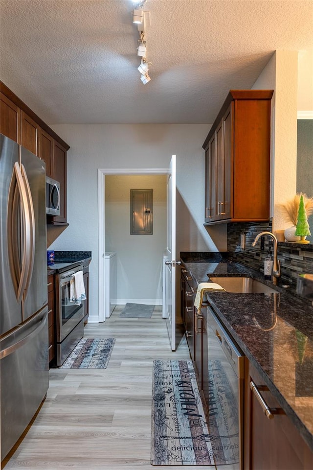 4221 W Spruce St Unit 1303, Tampa, FL 33607 - kitchen featuring appliances with stainless steel finishes, rail lighting, tasteful backsplash, dark stone counters, and a textured ceiling