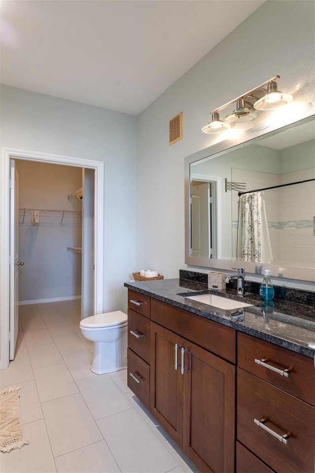 4221 W Spruce St Unit 1303, Tampa, FL 33607 - full bathroom featuring toilet, a spacious closet, vanity, tile patterned flooring, and a shower with curtain