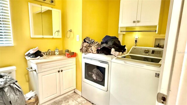 7012 Pin Cherry Ln, Port Richey, FL 34668 - washroom with independent washer and dryer, cabinet space, and light tile patterned floors