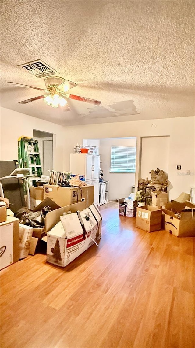 7012 Pin Cherry Ln, Port Richey, FL 34668 - living area with a textured ceiling, wood finished floors, and ceiling fan