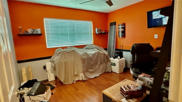7012 Pin Cherry Ln, Port Richey, FL 34668 - bedroom featuring wood finished floors, a textured ceiling, and ceiling fan