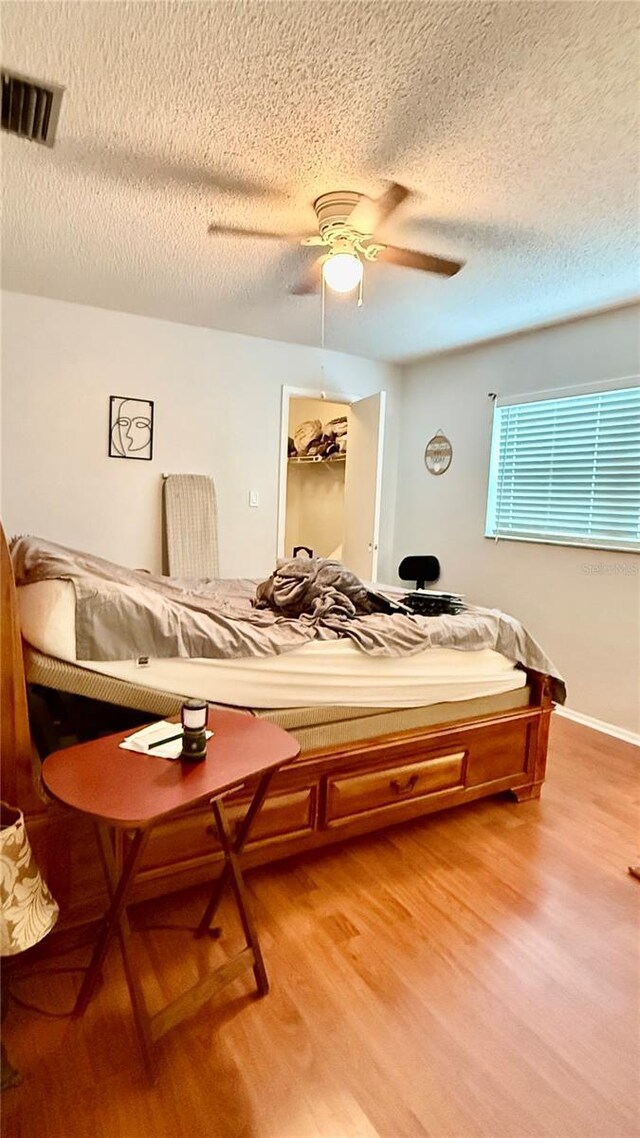 7012 Pin Cherry Ln, Port Richey, FL 34668 - bedroom with light wood-type flooring, a textured ceiling, and ceiling fan