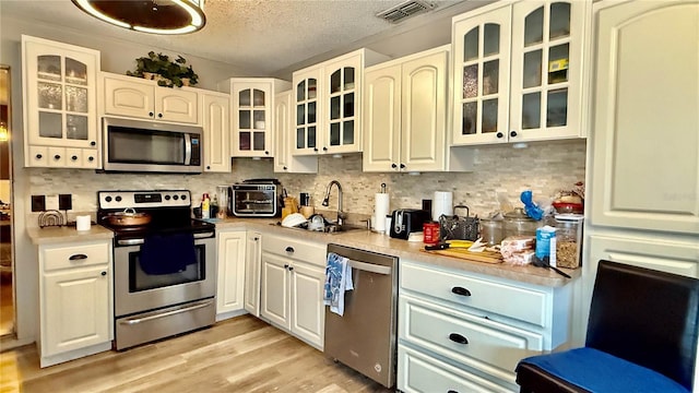 7012 Pin Cherry Ln, Port Richey, FL 34668 - kitchen with stainless steel appliances, a sink, light countertops, tasteful backsplash, and a textured ceiling