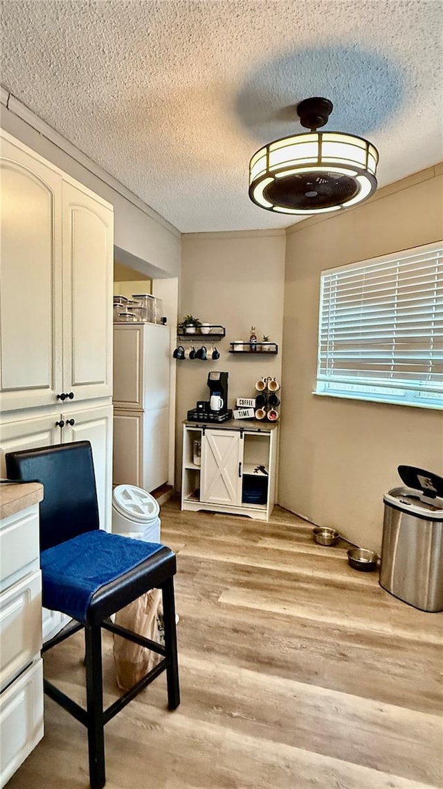 7012 Pin Cherry Ln, Port Richey, FL 34668 - dining area with a textured ceiling and light wood-style flooring