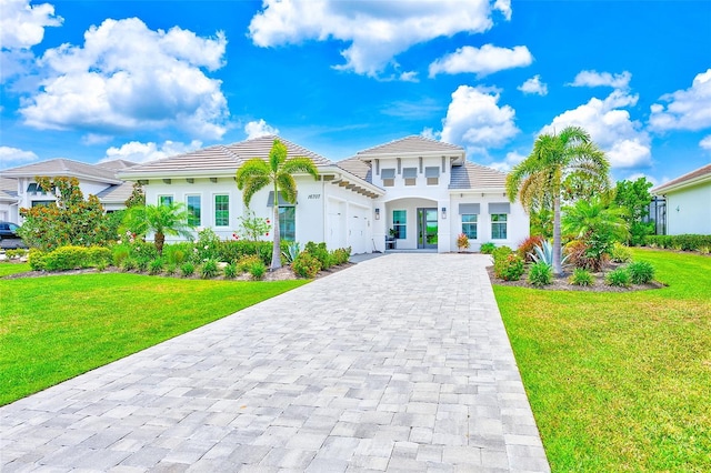 16707 Verona Pl, Bradenton, FL 34202 - mediterranean / spanish-style house featuring an attached garage, decorative driveway, a front lawn, a tiled roof, and stucco siding