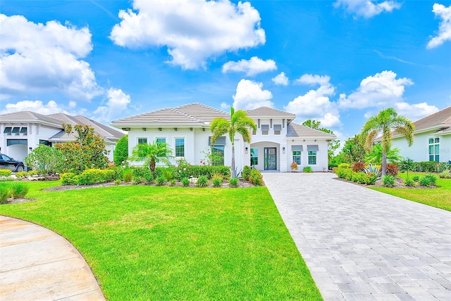 16707 Verona Pl, Bradenton, FL 34202 - mediterranean / spanish home with decorative driveway, a front lawn, and a tiled roof