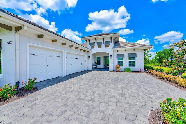 16707 Verona Pl, Bradenton, FL 34202 - view of front of home with decorative driveway, an attached garage, stucco siding, and a tiled roof