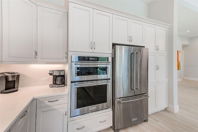 16707 Verona Pl, Bradenton, FL 34202 - kitchen featuring appliances with stainless steel finishes, light countertops, light wood-style flooring, and white cabinets
