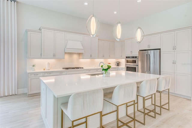 16707 Verona Pl, Bradenton, FL 34202 - kitchen with stainless steel appliances, premium range hood, a kitchen island with sink, light countertops, and recessed lighting