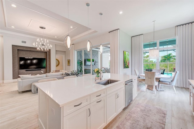 16707 Verona Pl, Bradenton, FL 34202 - kitchen with a chandelier, a tray ceiling, a center island with sink, stainless steel dishwasher, and light wood-style flooring
