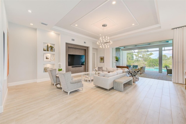 16707 Verona Pl, Bradenton, FL 34202 - living room with a tray ceiling, a chandelier, light wood finished floors, recessed lighting, and built in shelves