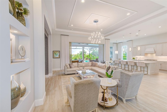 16707 Verona Pl, Bradenton, FL 34202 - living room featuring a tray ceiling, healthy amount of natural light, light wood finished floors, a chandelier, and recessed lighting