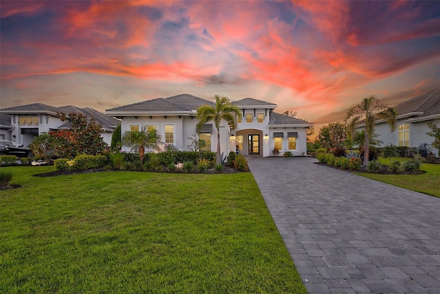 16707 Verona Pl, Bradenton, FL 34202 - mediterranean / spanish house with decorative driveway, a front yard, stucco siding, and a tile roof