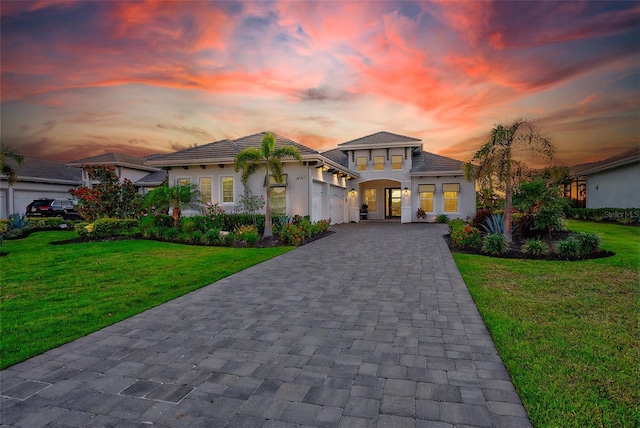 16707 Verona Pl, Bradenton, FL 34202 - mediterranean / spanish home with decorative driveway, a front yard, stucco siding, and an attached garage