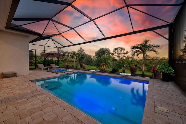16707 Verona Pl, Bradenton, FL 34202 - pool at dusk featuring an in-ground hot tub, an outdoor pool, a patio area, and a diving board