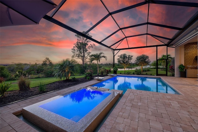 16707 Verona Pl, Bradenton, FL 34202 - pool at dusk with an outdoor pool, a patio, an in-ground hot tub, and glass enclosure