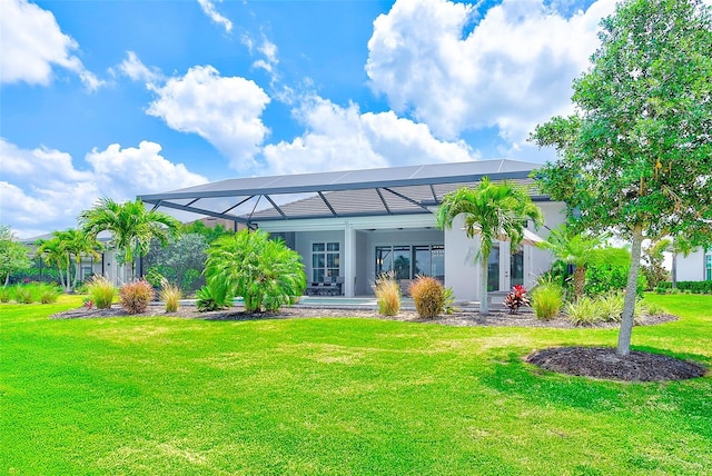 16707 Verona Pl, Bradenton, FL 34202 - back of house with a lawn, glass enclosure, and stucco siding