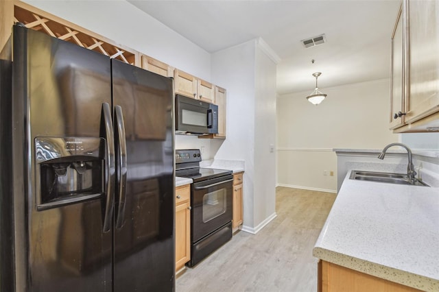 kitchen featuring black appliances, a sink, light wood-style flooring, baseboards, and pendant lighting