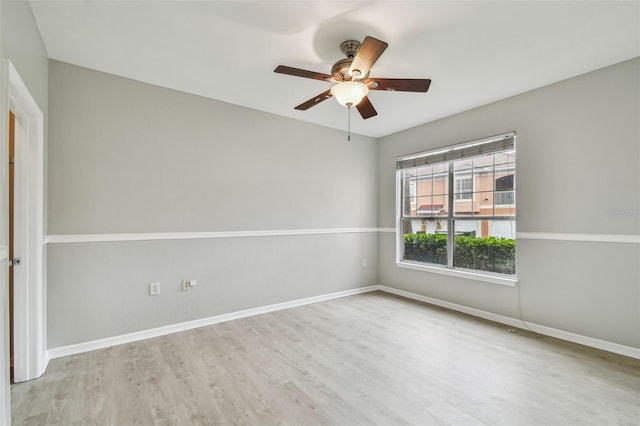 spare room featuring a ceiling fan, wood finished floors, and baseboards