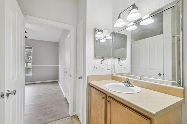 bathroom with vanity, baseboards, and wood finished floors