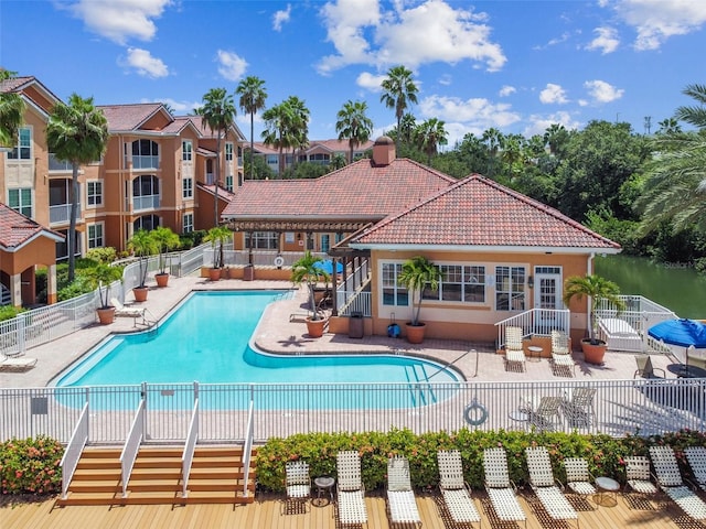 community pool with a patio and fence