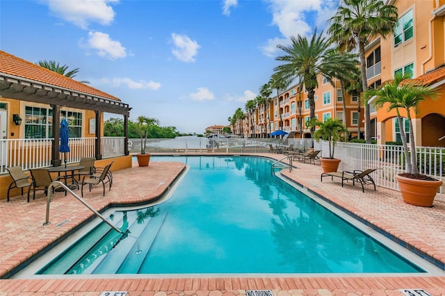 community pool with fence and a patio area