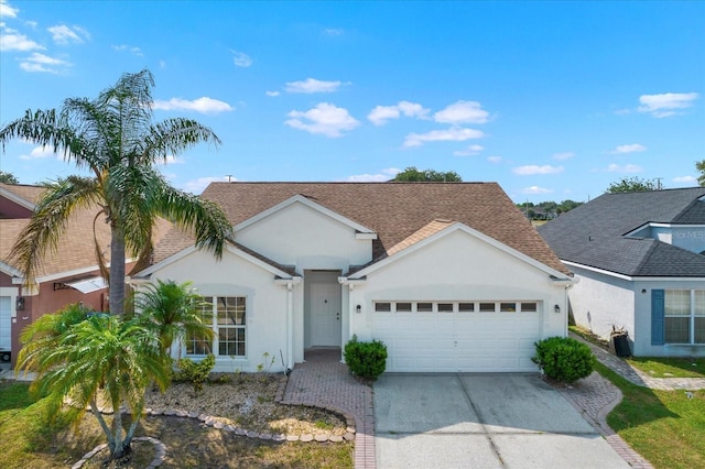 11307 Calgary Cir, Tampa, FL 33624 - view of front of home with a garage, stucco siding, concrete driveway, and a shingled roof