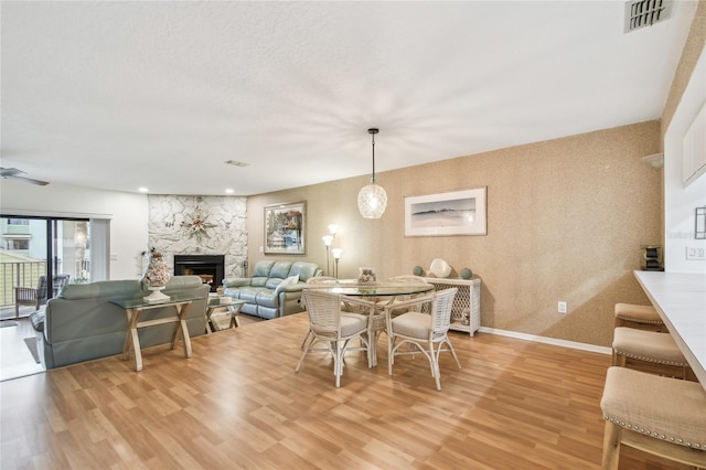 531 Sandy Hook Rd, Treasure Island, FL 33706 - dining room with light wood-style flooring, a fireplace, baseboards, and ceiling fan