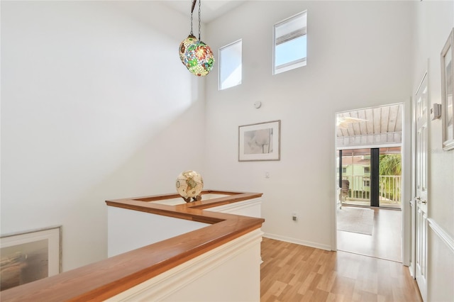 531 Sandy Hook Rd, Treasure Island, FL 33706 - hallway featuring plenty of natural light, light wood-style floors, a high ceiling, and baseboards