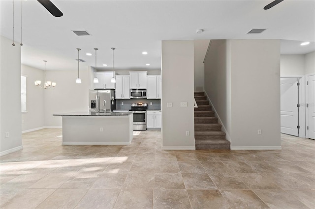 13233 Canopy Creek Dr, Tampa, FL 33625 - kitchen featuring appliances with stainless steel finishes, a ceiling fan, baseboards, white cabinetry, and recessed lighting