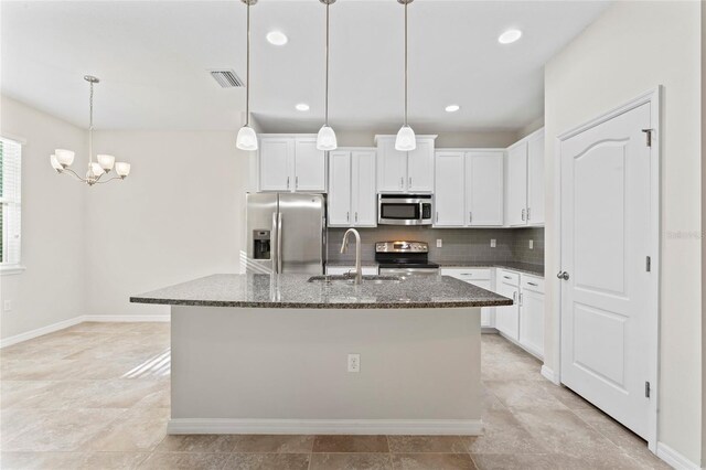 13233 Canopy Creek Dr, Tampa, FL 33625 - kitchen with stainless steel appliances, a sink, dark stone counters, a chandelier, and backsplash