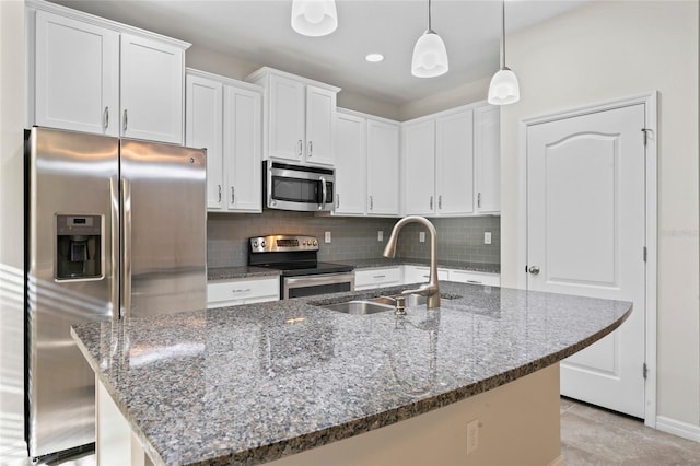 13233 Canopy Creek Dr, Tampa, FL 33625 - kitchen with stainless steel appliances, a sink, backsplash, white cabinetry, and an island with sink