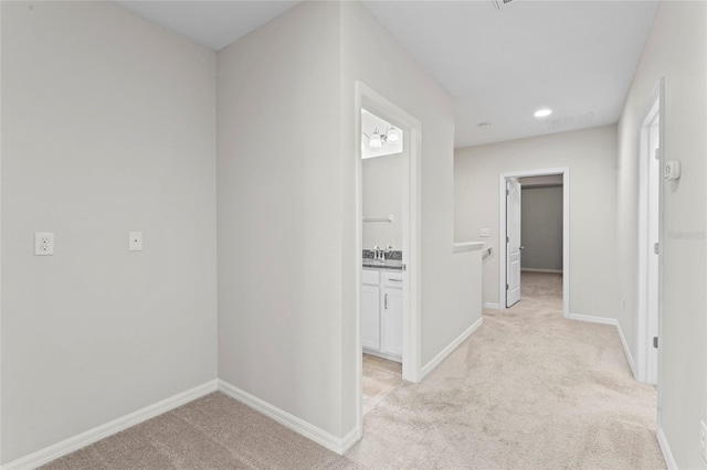 13233 Canopy Creek Dr, Tampa, FL 33625 - hallway featuring light colored carpet, baseboards, recessed lighting, and a sink