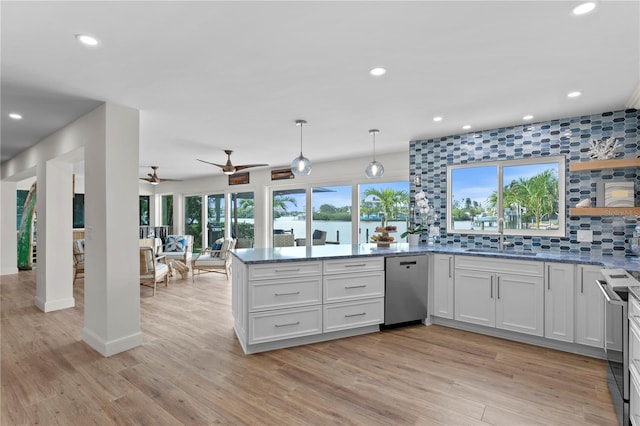243 Hermosita Dr, St Pete Beach, FL 33706 - kitchen with a sink, a peninsula, dishwasher, range, and decorative backsplash