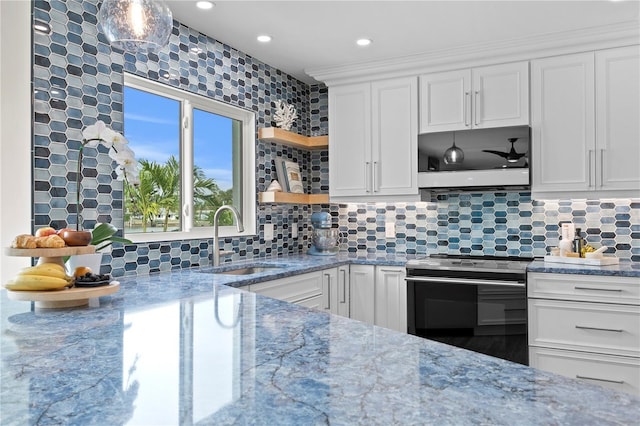 243 Hermosita Dr, St Pete Beach, FL 33706 - kitchen with stainless steel electric stove, a sink, open shelves, white cabinetry, and light stone counters