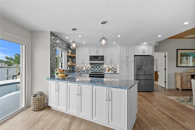 243 Hermosita Dr, St Pete Beach, FL 33706 - kitchen featuring appliances with stainless steel finishes, a peninsula, white cabinets, backsplash, and stone countertops