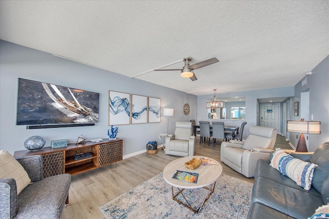 15000 Gulf Blvd Unit 602, Madeira Beach, FL 33708 - living area with wood finished floors, a ceiling fan, a textured ceiling, and baseboards