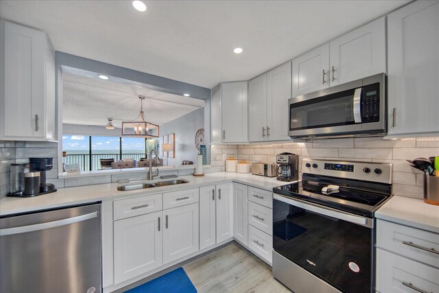 15000 Gulf Blvd Unit 602, Madeira Beach, FL 33708 - kitchen featuring appliances with stainless steel finishes, a sink, tasteful backsplash, white cabinets, and recessed lighting
