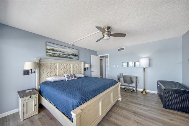 15000 Gulf Blvd Unit 602, Madeira Beach, FL 33708 - bedroom featuring wood finished floors, a textured ceiling, baseboards, and ceiling fan