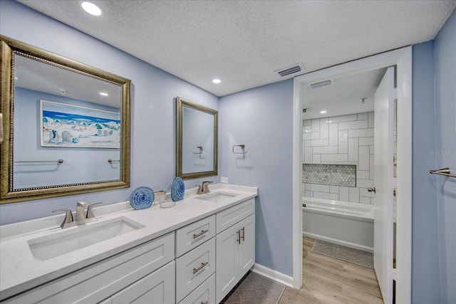 15000 Gulf Blvd Unit 602, Madeira Beach, FL 33708 - bathroom featuring a textured ceiling, double vanity, wood finished floors, recessed lighting, and shower / washtub combination