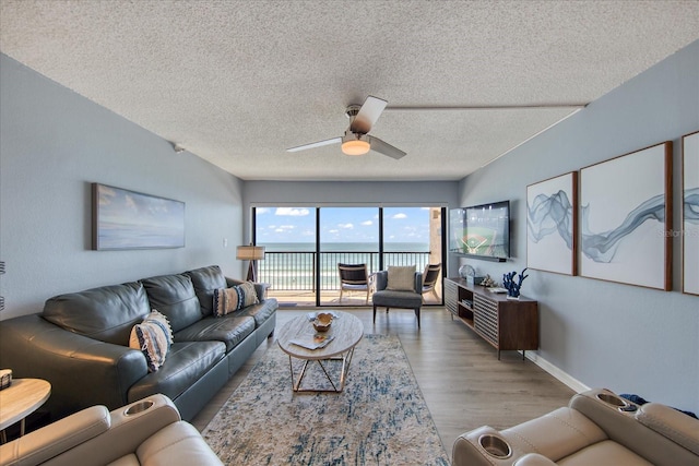 15000 Gulf Blvd Unit 602, Madeira Beach, FL 33708 - living room featuring wood finished floors, a textured ceiling, a ceiling fan, and baseboards