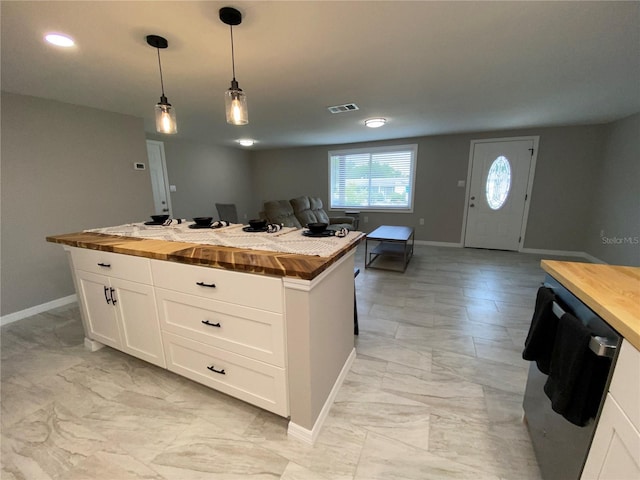 kitchen featuring wooden counters, baseboards, light marble finish floors, white cabinets, and recessed lighting