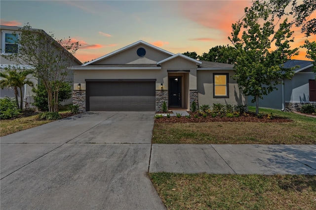 view of front of property with a garage, stucco siding, stone siding, and concrete driveway