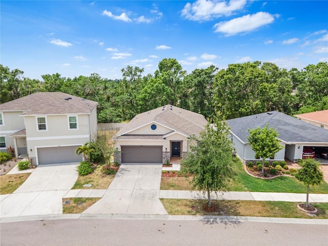 view of front facade featuring concrete driveway, stucco siding, a shingled roof, and a front yard
