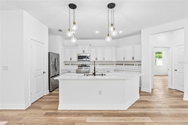 kitchen with stainless steel appliances, a sink, light countertops, backsplash, and recessed lighting