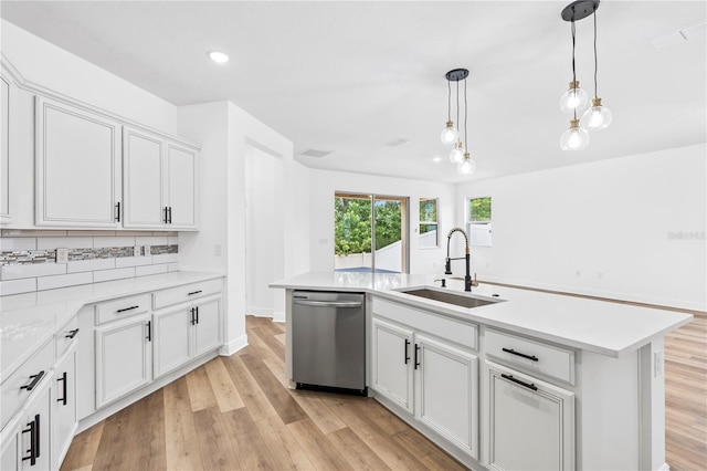 kitchen featuring stainless steel dishwasher, a sink, light wood-style floors, light countertops, and recessed lighting