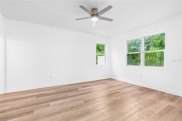 spare room with light wood-style flooring, baseboards, and ceiling fan