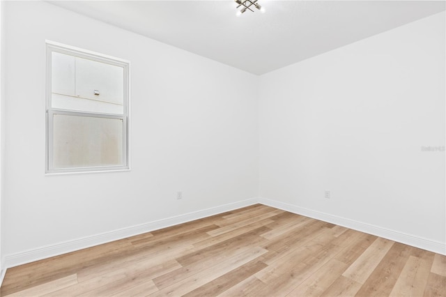 empty room featuring light wood-style flooring and baseboards