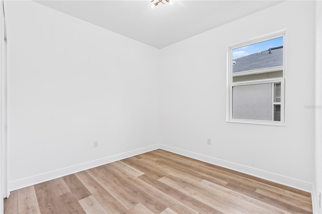 spare room featuring baseboards and light wood-style flooring